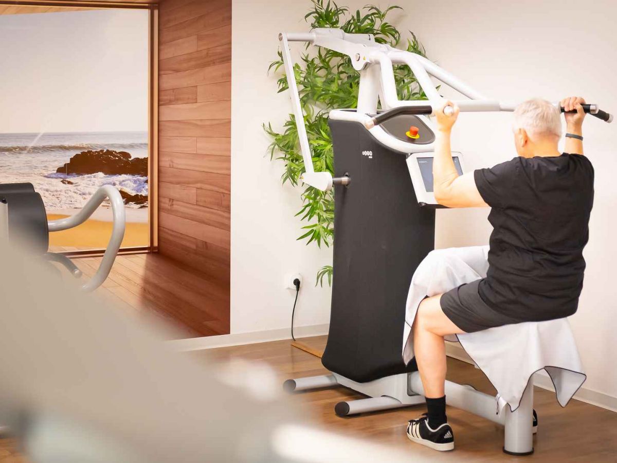 Älterer Mann am Latzug