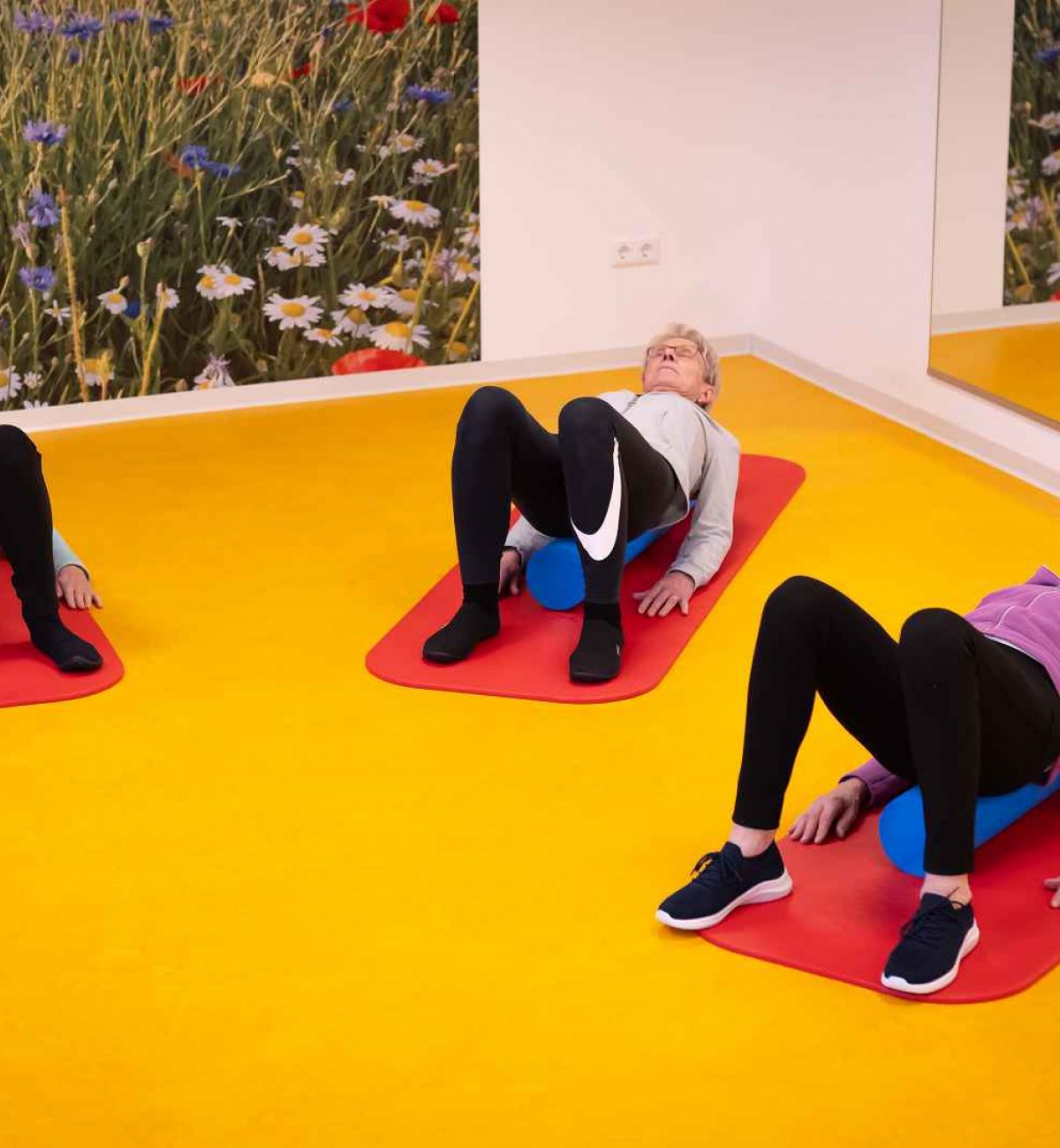 Menschen liegen im Fitnessraum auf Matten